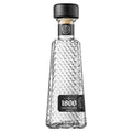 Clear glass bottle with diamond pattern and black cap on a white background